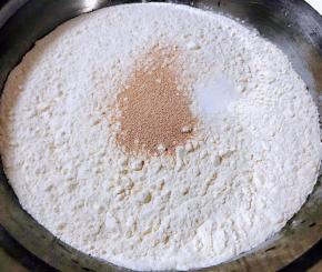 准备适量面粉、盐、酵母粉倒入温水搅拌成絮状再和成面团盖上盖莲开始发酵