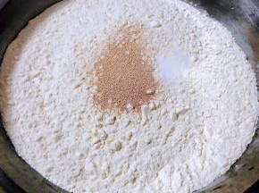 准备适量面粉、盐、酵母粉倒入温水搅拌成絮状再和成面团盖上盖莲开始发酵