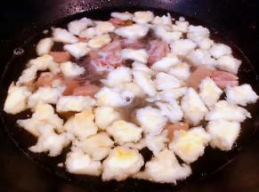  炖好的羊肉和原汁原味的汤汁倒入锅中再放入掰好的馍大火煮起来