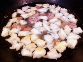  炖好的羊肉和原汁原味的汤汁倒入锅中再放入掰好的馍大火煮起来