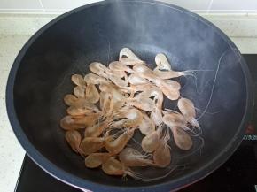 锅里放适量的油把葱白爆香，放虾爆炒加一勺料酒。