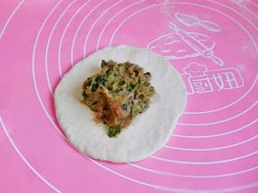 取一个小面团，擀成面皮，放上适量的馅料。