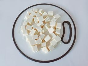 将豆腐横着对半切一下，再切成5mm左右小块。