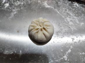 这是做好的一个包子，我做的也不好，这个要多多练习。虽然大家都喜欢吃皮薄馅大的包子，但建议新手还是肉馅放少一点，这样好包。等熟练了，再放多一点肉馅。