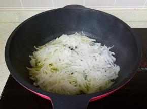 热锅热油放入萝卜丝翻炒。