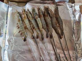 5、烤箱200度预热。烤盘上垫好锡纸，刷上一层橄榄油，将腌制好的虾用烤钎整只串起来！整齐码好。