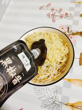 碗中放入绿豆芽和碱面，再放入适量的黑椒酱拌匀！