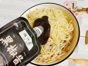 碗中放入绿豆芽和碱面，再放入适量的黑椒酱拌匀！
