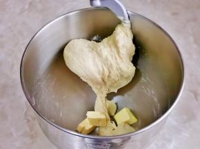 这时面团处于扩展阶段，加入室温软化的黄油继续揉面。