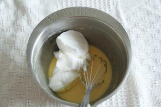 取1/3蛋白霜入蛋黄糊中，左手配合逆时针转盆，右手用蛋抽从2点钟方向切入，从盆底划到7点钟方向翻起到盆中心，重复动作，初步混匀。