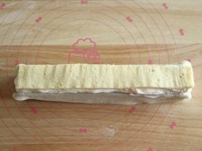 再挤上一层奶油，将草莓完全覆盖，然后放上一条蛋糕胚（哪一面朝上都可以）