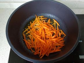 锅里放适量的食用油，油热放入胡萝卜丝煸炒。
