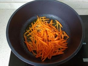 锅里放适量的食用油，油热放入胡萝卜丝煸炒。