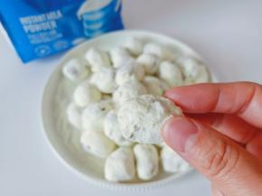 趁热揪下来，团成一个一个的小圆球，再放入奶粉里，让每个奶枣表面都裹上一层奶粉。