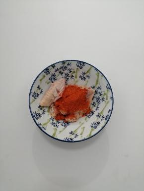 在把鸡翅放入碗中加入奥尔良腌料