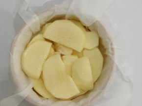 把苹果均匀的摆在铺有油纸的烤碗中