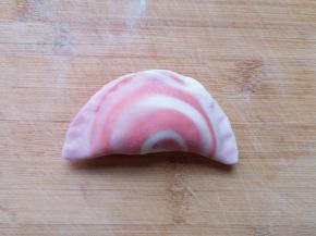 取一个蒸饺皮放上荠菜馅，将边缘捏紧。