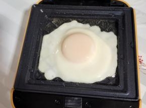 比依三明治机提前预热，刷适量的油，打入一个鸡蛋煎熟！(盖上盖子大约2分钟左右就好！)