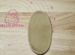 取一松弛好的面团，拍扁，擀开成长条形。