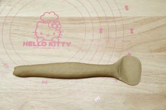 然后双手轻轻按住面团，上下来回搓成25厘米的长条状。收口朝上，一头搓细，一头按扁，用擀面杖擀开成面片。