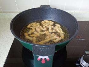 锅中加适量油，油温六成热将肉块一条一条入锅中油炸。