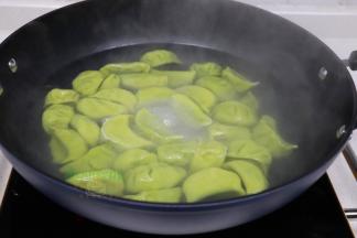 倒入适量的水，旺火煮沸，放入饺子，然后筷子轻松松散，别让饺子粘在一起。