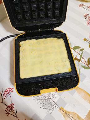 从中央倒入面糊，使面糊均匀的盖住华夫饼烤盘！