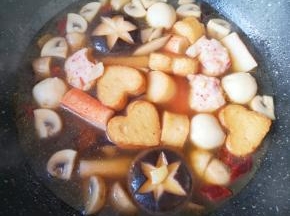 煮至丸子飘起，下入蟹味棒。