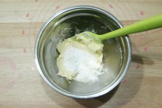 软化好的黄油倒入糖粉，用刮刀先按压混合，防止糖粉飞溅。