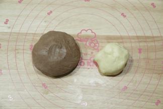 用刮刀切拌按压到没有干粉颗粒，戴上PVC手套按压成团，分出一部分原色面团，其余面团放入可可粉，揉成均匀的可可面团！（具体分量看自己想要做哪种柴犬，计算一下即可）