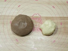 用刮刀切拌按压到没有干粉颗粒，戴上PVC手套按压成团，分出一部分原色面团，其余面团放入可可粉，揉成均匀的可可面团！（具体分量看自己想要做哪种柴犬，计算一下即可）