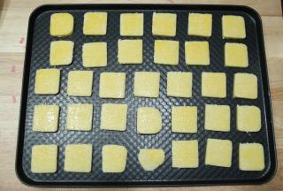 裹好保鲜膜冷冻30分钟定型。预热烤箱上下180度，取出定型好的胚切块，一条可以切出32块饼干胚。均匀排列入烤盘（头尾不平整的可以切掉，一起放入烤），半个蛋黄过筛后加一点牛奶，搅匀成蛋黄液，均匀刷一层在饼干胚上。
