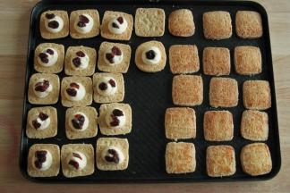 将一半饼干翻面，中间挤上一球奶酪霜，放上2-3个蔓越莓，喜欢吃可以多加一些。