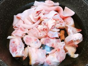 猪蹄斩件跟猪皮一起放入锅里，加入姜片、料酒，花椒粒煮5分钟