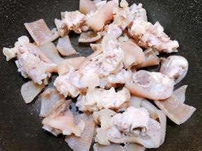 冲洗干净后猪蹄放入锅里，猪皮用刀划去肥肉冲洗干净后放入锅里，加入1小勺盐把水份炒干