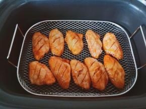 空气炸锅提前开启预热功能，预热好后把腌制好的鸡翅摆放好。