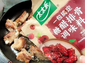 放入适量的糖醋排骨调味料，翻炒片刻！