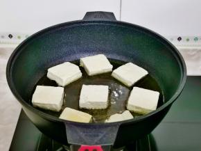 起油锅油，油温六成热时，将臭豆腐摆入锅中。