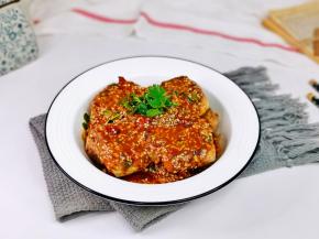 把酱汁淋在炸好的臭豆腐上，点缀上香菜。