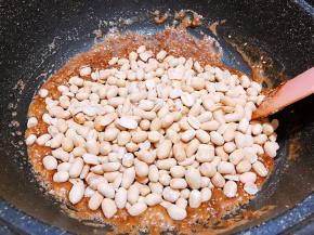 倒入花生仁后关火，用铲子不停的翻炒
