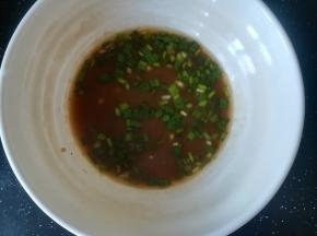 舀几勺面汤倒入碗中