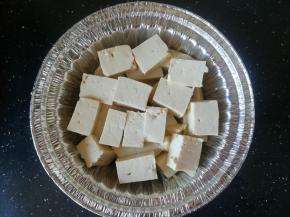 豆腐切成块，放入锡纸碗中