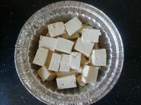 豆腐切成块，放入锡纸碗中