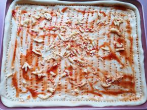 在饼底涂上番茄酱，撒上一层马苏里拉芝士。 