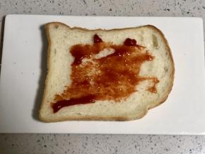 在吐司片上抹上番茄酱;