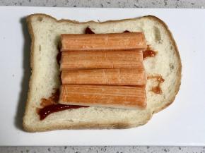 然后在吐司片上依次放上解冻好的蟹肉棒;