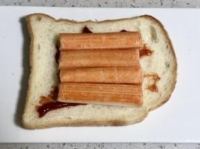 然后在吐司片上依次放上解冻好的蟹肉棒;