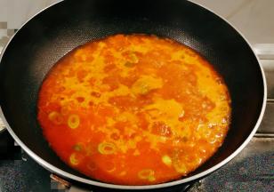 起油锅放入食用油，油热后放入葱片炒香，放入番茄块翻炒成酱，倒入清水煮开。