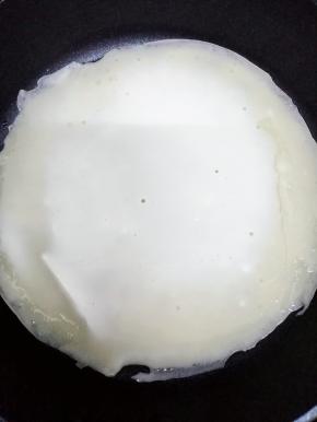 平底锅加入少许的油，然后舀二勺面糊倒入摊平