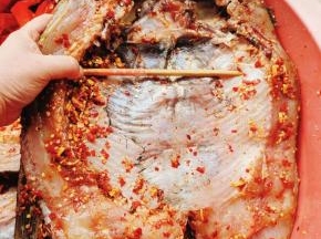 腌制好后用筷子把鱼肚子撑开，这样晾晒的时候比较容易干！